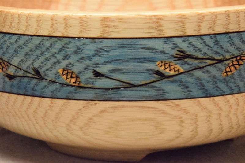 Pine Motif on Blue Gilder's Paste: Close-up of a pine branch and pinecone band on ash